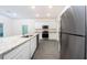 Modern kitchen featuring a center island, stainless steel appliances, and gray wood-look flooring at 13490 Leaping Water Way, Astatula, FL 34705