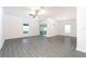 Large living room featuring gray flooring, windows, a sliding door, and modern ceiling fan at 13490 Leaping Water Way, Astatula, FL 34705