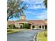 A welcoming clubhouse featuring a terracotta tile roof, decorative landscaping, and a grand entrance at 3825 Quaint Ln # C, Clermont, FL 34711