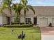 Charming townhome with a manicured lawn, palm trees, and brick paver driveway, offering curb appeal at 3825 Quaint Ln # C, Clermont, FL 34711