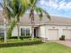 Beautiful townhome featuring lush landscaping, mature palm trees, and a well-maintained lawn at 3825 Quaint Ln # C, Clermont, FL 34711