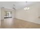 Spacious open-concept living area featuring tile flooring, modern ceiling fan, and sliding glass doors at 3825 Quaint Ln # C, Clermont, FL 34711