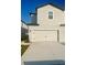 Two-story home featuring a large garage with black hardware, a concrete driveway, and neutral colored siding at 775 Poppy Ln, Dundee, FL 33838