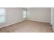 Spacious bedroom featuring neutral carpet, two large windows, and bright neutral paint at 9569 Sw 62Nd Ct, Ocala, FL 34476
