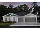 Two-story home with gray and green exterior, two-car garage, and landscaped yard at 6013 Sw 96Th Pl, Ocala, FL 34476
