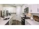 Modern kitchen with stainless steel appliances and white cabinets at 6013 Sw 96Th Pl, Ocala, FL 34476