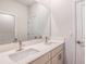 Contemporary bathroom featuring double vanity with white marble countertops, framed mirror, and white walls at 6062 Sw 97Th St, Ocala, FL 34476
