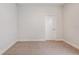 A neutral carpeted bedroom with a bright neutral palette and a closed door at 6062 Sw 97Th St, Ocala, FL 34476