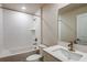 Modern bathroom with a white tub, sink, and unique textured wall tiles at 6218 Sw 95Th Pl, Ocala, FL 34476