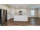 Bright kitchen boasts stainless steel appliances, center island, and stylish wood-look flooring at 6218 Sw 95Th Pl, Ocala, FL 34476
