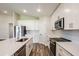 Bright kitchen boasts stainless steel appliances, center island, and stylish wood-look flooring at 6218 Sw 95Th Pl, Ocala, FL 34476