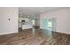 Open floor plan with wood flooring, leading to the kitchen and an outdoor sliding glass door at 6218 Sw 95Th Pl, Ocala, FL 34476