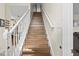 Elegant staircase featuring wood treads and white risers, with natural light enhancing the architectural details at 2644 W 75Th Blvd, Bushnell, FL 33513