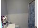 Neutral bathroom featuring a toilet, sink, and tub with a seashell shower curtain at 1019 Milner E Dr, Lakeland, FL 33810