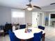 Bright dining room with white table, blue upholstered chairs, and modern ceiling fan fixture at 1019 Milner E Dr, Lakeland, FL 33810