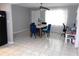 Open dining area with white tile flooring and blue upholstered chairs beneath a modern ceiling fan at 1019 Milner E Dr, Lakeland, FL 33810