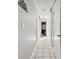 Hallway with white tile flooring and view of lighted vanity at 1019 Milner E Dr, Lakeland, FL 33810