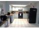Well-lit kitchen featuring light blue cabinetry, black appliances, and light countertops at 1019 Milner E Dr, Lakeland, FL 33810