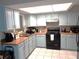 Bright kitchen with light blue cabinets, black appliances, and light countertops at 1019 Milner E Dr, Lakeland, FL 33810