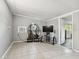 Neutral living area with tiled floor, entertainment center, shelving with plants, and a window air conditioner at 1019 Milner E Dr, Lakeland, FL 33810