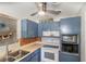 White appliances and blue cabinets in this well-lit kitchen at 1284 Vanderbilt Dr, Ormond Beach, FL 32174