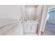 Bright bathroom with a walk-in tub with safety grab bars and tiled surround at 6855 Mossy Oak Ln, Lakeland, FL 33810