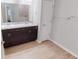 Bathroom featuring double sink vanity with dark cabinets and wood-look flooring at 6855 Mossy Oak Ln, Lakeland, FL 33810