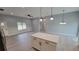 Open living room and kitchen area with an island and modern lighting fixtures at 13898 Sw 32Nd Ter, Ocala, FL 34473