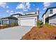 Two-story home with a white garage door, exterior lighting, and manicured landscaping at 3007 Mirage Pl, St Cloud, FL 34771
