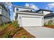 Stylish home with a white garage door, attractive exterior lighting, and fresh landscaping at 3007 Mirage Pl, St Cloud, FL 34771