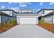 Modern two-story home with a white garage door, concrete driveway and manicured landscaping at 3007 Mirage Pl, St Cloud, FL 34771