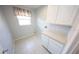 Practical laundry room featuring white cabinets, countertop space, and tile flooring at 2819 Ne 25Th St, Ocala, FL 34470