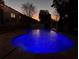 Inviting backyard pool illuminated by a beautiful sunset and ambient string lights, perfect for evening swims at 2819 Ne 25Th St, Ocala, FL 34470