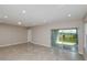 Bright living room with recessed lighting, tile floors, and a sliding glass door leading to the outside at 5429 Sw 85Th Avenue Rd, Ocala, FL 34481