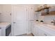 Bright laundry room with white cabinets, a utility sink, and built-in shelving at 5813 Sw 87Th Court Rd, Ocala, FL 34481