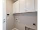 Functional laundry room with upper cabinets, utility connections, and beige walls, providing practicality at 5813 Sw 87Th Court Rd, Ocala, FL 34481