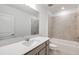 Modern bathroom with a large mirror, quartz countertop, and a tiled shower/tub combo at 8319 Sw 54Th Loop, Ocala, FL 34481