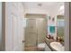 Bathroom features a glass-enclosed shower and functional vanity with granite-look countertop at 4995 County Road 121D, Wildwood, FL 34785