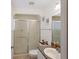 Bathroom features a glass-enclosed shower and functional vanity with granite-look countertop at 4995 County Road 121D, Wildwood, FL 34785
