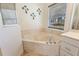 Relaxing bathroom view with a large garden tub surrounded by tile, with a large window and decorative palm tree ornaments at 4995 County Road 121D, Wildwood, FL 34785