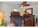 Bedroom featuring a decorative ceiling fan, accent window and hardwood floors at 4995 County Road 121D, Wildwood, FL 34785