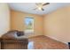 Bedroom with neutral walls, a ceiling fan, tile flooring, and a window offering exterior views at 4995 County Road 121D, Wildwood, FL 34785
