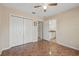 Neutral bedroom with tile flooring, ceiling fan, and double door closet at 4995 County Road 121D, Wildwood, FL 34785
