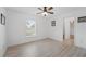 Bedroom with laminate flooring, ceiling fan, and view to outside at 4995 County Road 121D, Wildwood, FL 34785