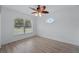 Bedroom with laminate flooring, ceiling fan, and multiple windows at 4995 County Road 121D, Wildwood, FL 34785