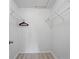 Bright walk-in closet with white wire shelving and wood-look laminate flooring at 4995 County Road 121D, Wildwood, FL 34785