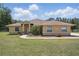 Charming single-story home with a well-manicured lawn and beautiful landscaping at 4995 County Road 121D, Wildwood, FL 34785