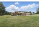 Spacious single-story home featuring a detached garage and a lush green yard at 4995 County Road 121D, Wildwood, FL 34785