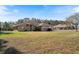 Single-Gathering home with a large front yard and mature trees at 4995 County Road 121D, Wildwood, FL 34785