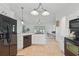 Modern kitchen with white cabinetry, black appliances, and an open view into the living room at 4995 County Road 121D, Wildwood, FL 34785
